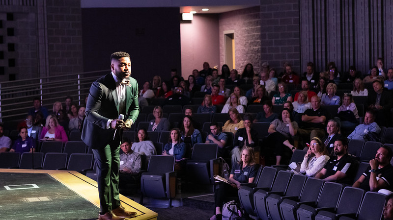 Brandon Fleming speaks to attendees from stage at the Indiana Early College Summit