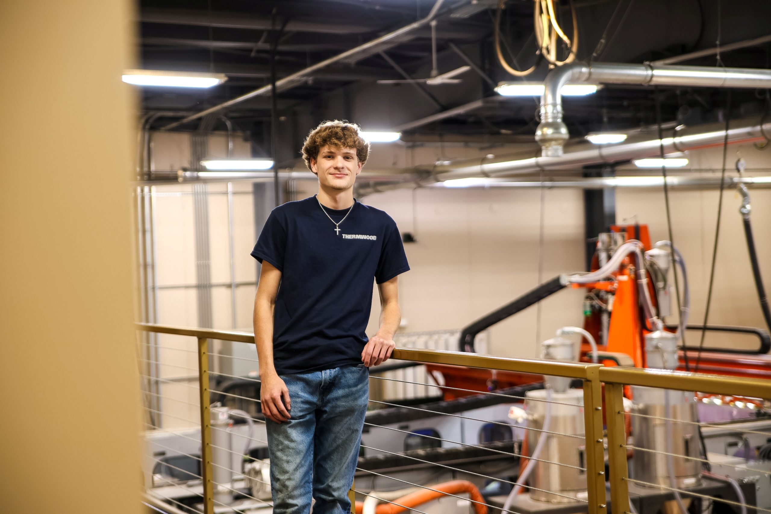 Person smiling at camera with machinery in background